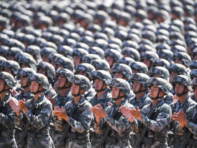 Chinese soldiers applauding during a military parade. Beijing’s military can now be found as far afield as Africa. Picture: AFP